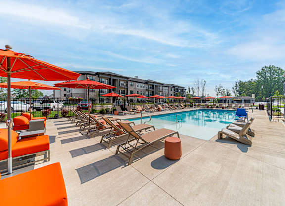 A pool area with sun loungers and umbrellas.
