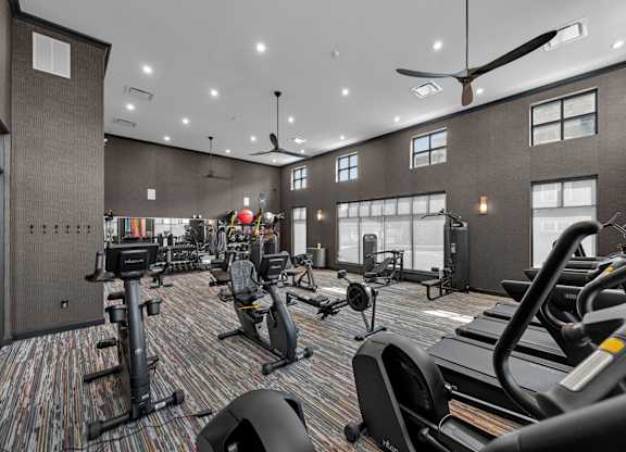 A gym with treadmills, elliptical machines, and other exercise equipment.