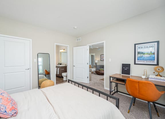 a bedroom with a bed and a desk with a mirror