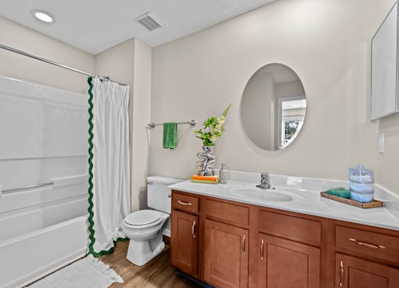 A bathroom with a toilet, sink, and shower.