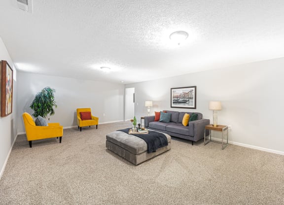 finished basement with a couch and chairs and a