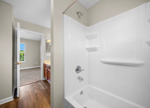 A white bathroom with a tub and a shower.