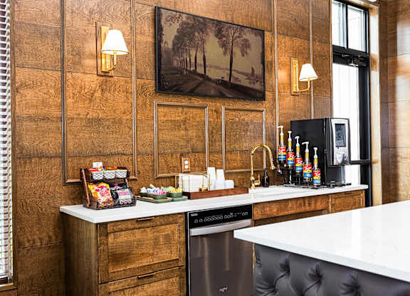 A kitchen with a white counter top and a black dishwasher.