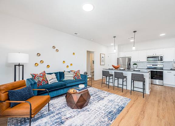 A modern living room with a blue sofa and orange armchair.