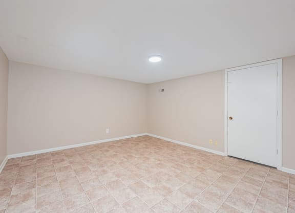 an empty living room with a door to a closet