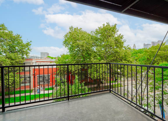 the balcony has a view of the park and the city