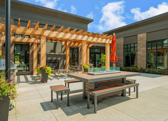 a patio with tables and benches outside of a building