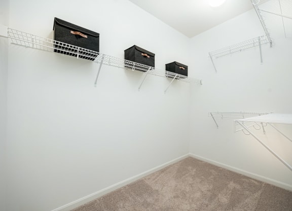 a spacious closet with shelves and hanging racks on the wall