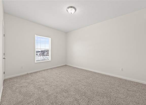 A room with a carpeted floor and a window.