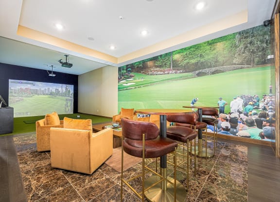 a clubhouse with a large wall mural of a golf course on the wall and chairs