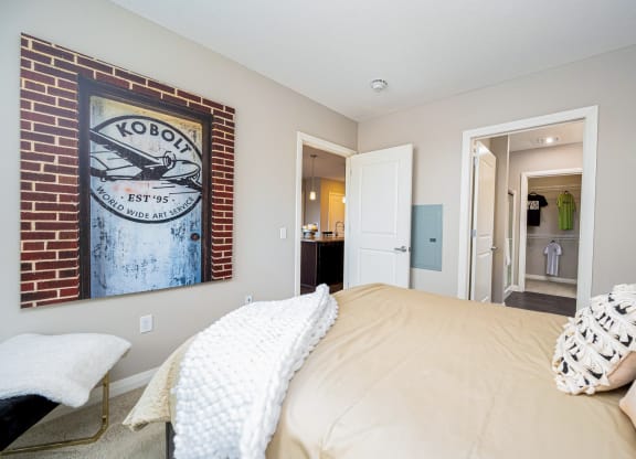 a bedroom with a bed and a painting on the wall