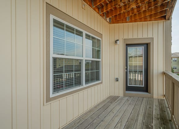 the front porch of a home with a door and windows
