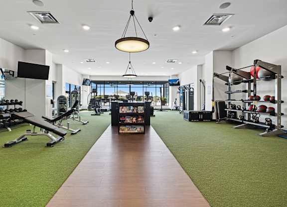 A gym with a variety of equipment and a green carpet.