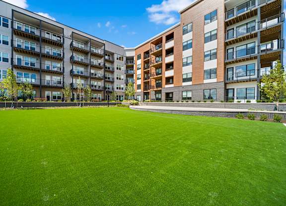 A large grassy area in front of apartment buildings.