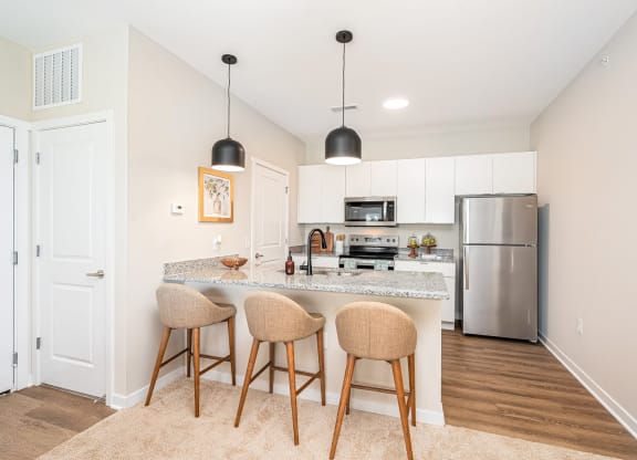 a kitchen with a marble counter top and bar stools