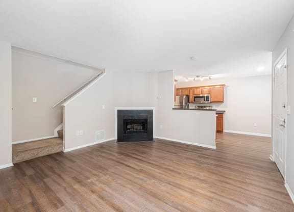 a living room with a fireplace and wooden floors