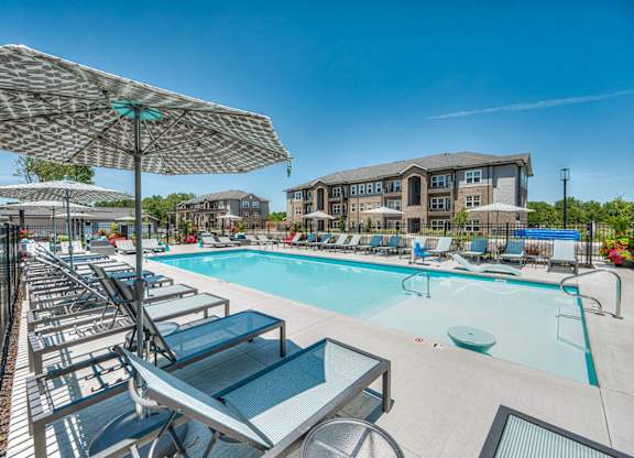 A sunny day at the pool with lounge chairs and umbrellas.