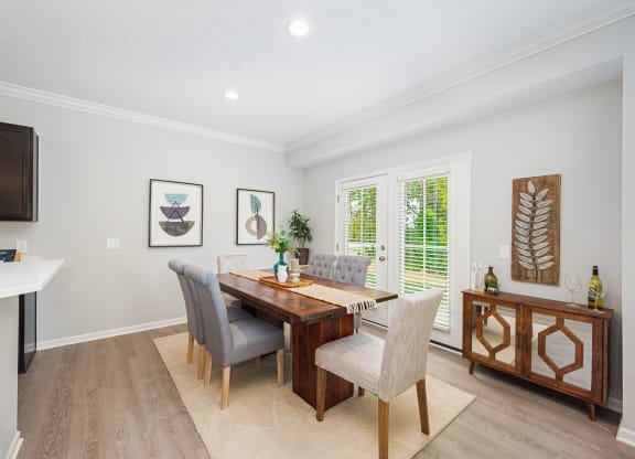a dining room with a wooden table and chairs