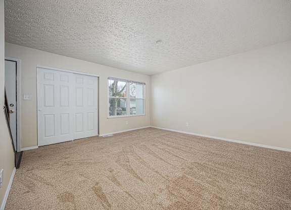 A room with a carpeted floor and a white door.