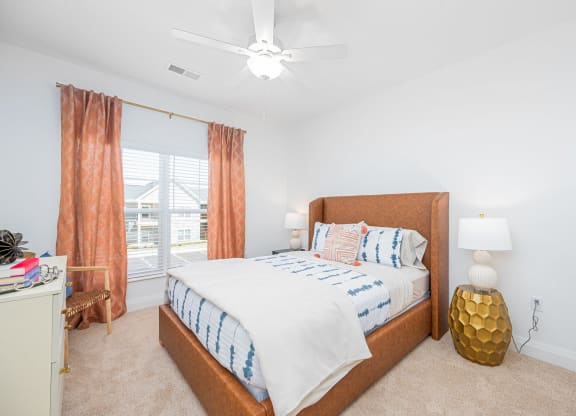 a bedroom with a bed and a ceiling fan