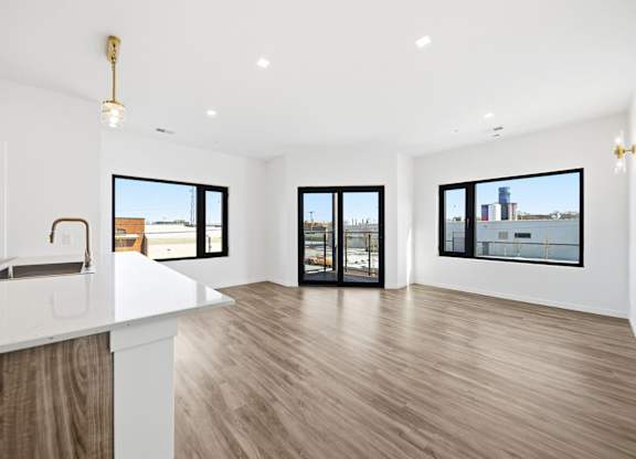 A spacious room with a white counter and wooden flooring.