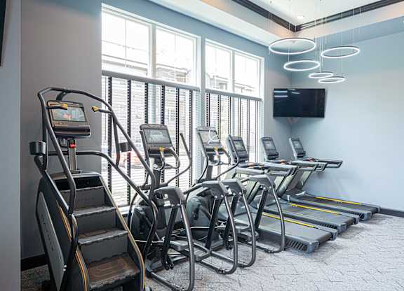 A gym with treadmills, elliptical machines, and a stair climber.