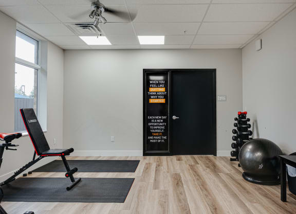 a fitness room with a yoga ball and chair and a door to the gym