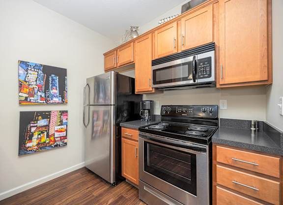 A kitchen with a stainless steel refrigerator, oven, and microwave.