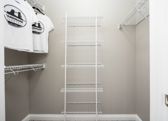 a walk in closet with a wire closet organizer and a shirt hanging on a rack