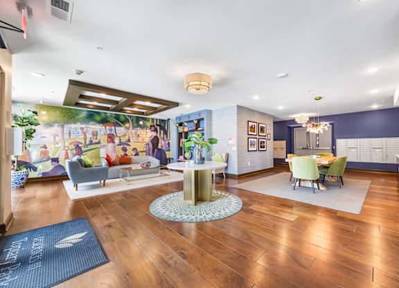 A living room with a wooden floor and a large mural on the wall.