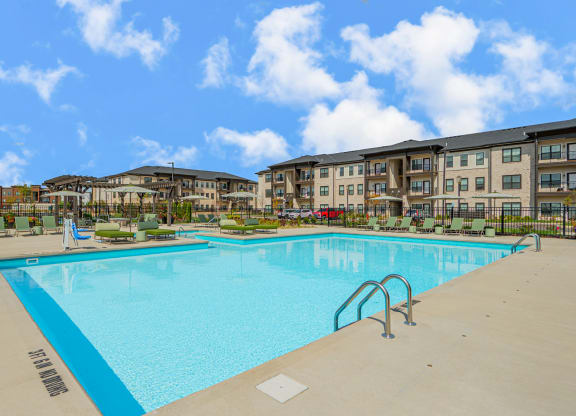a swimming pool with an apartment building in the background