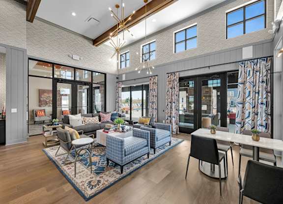 A modern living room with a blue rug and a dining table.
