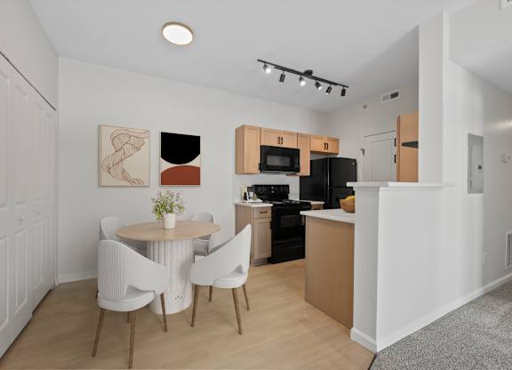 A modern kitchen with a dining table and chairs.