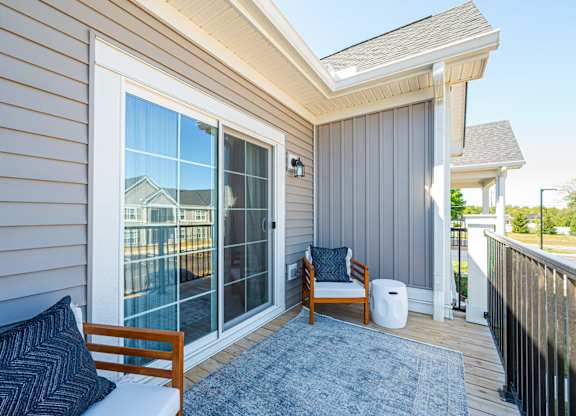 A small balcony with a chair and a pillow.