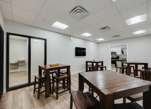 a dining room with tables and chairs and a tv on the wall