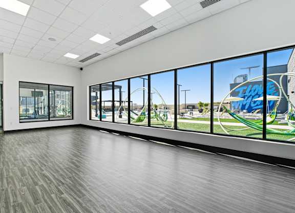 A spacious room with a view of a playground through the windows.