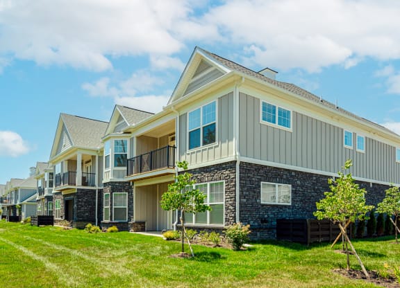 a row of houses with grass and trees in front of them