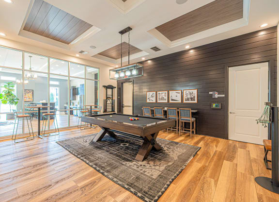 a game room with a pool table and a bar