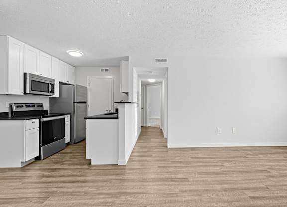 A kitchen with white cabinets and appliances.