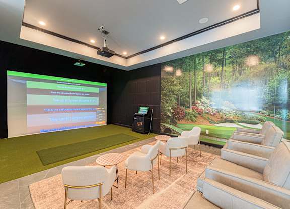 A presentation room with a screen and a green carpet.