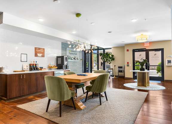 A modern dining room with a wooden table and green chairs.