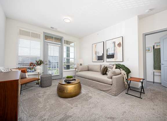 A living room with a couch, coffee table, and pictures on the wall.