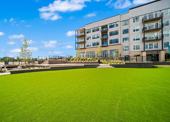 A large grassy area in front of a multi-story building.