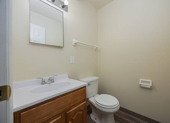 A white sink with a mirror above it and a toilet in a bathroom.