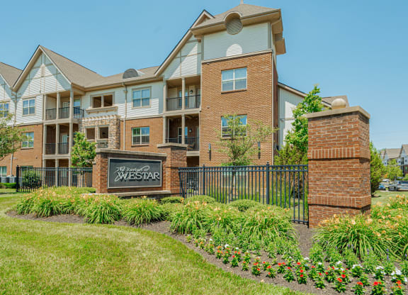 an apartment building with a sign in front of it