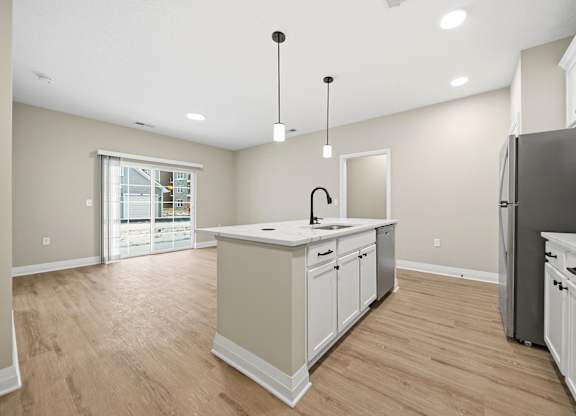 A kitchen with a sink, stove, and refrigerator.