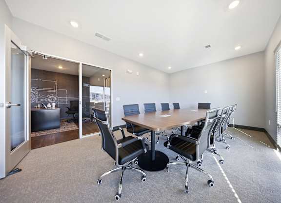 A conference room with a table and chairs.