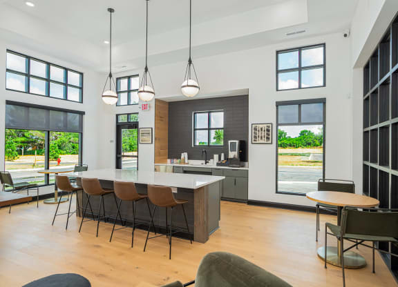 a living room with a kitchen and a table with chairs