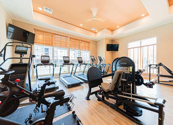 A gym with treadmills, exercise bikes, and other equipment.