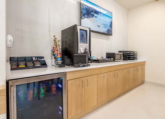 A kitchen with a refrigerator, microwave, and oven.
